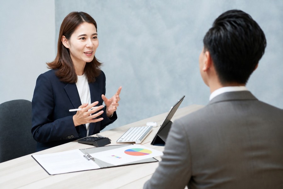 WISELOOP 顧問與企業主管進行需求訪談，桌上放著分析報表與平板